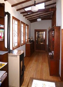 薔薇窓のある部屋から階段を3段下がった展示室、元薬局の家具が並ぶ